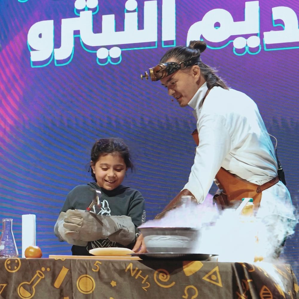 Live science show at the NSTI Festival with a young volunteer – education sector marketing Dubai